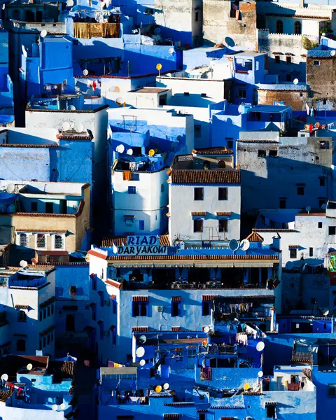 A cityscape with many blue and white houses standing close together.