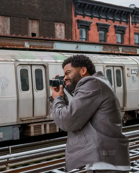 Man photographs a train with a Leica M11