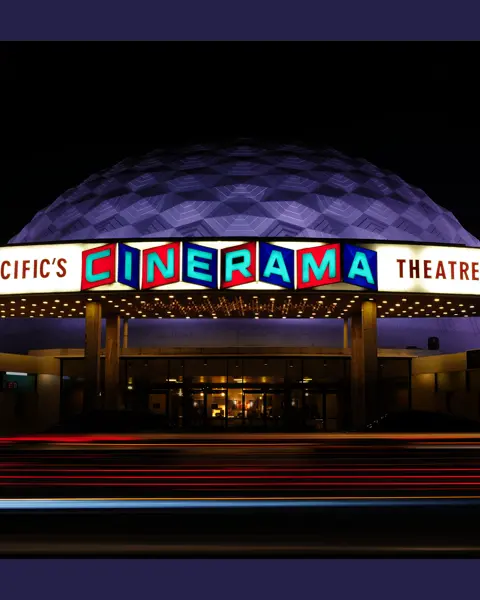 Luminous Cinerama theatre at night.