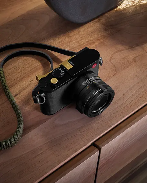 A Leica camera resting on a wooden table