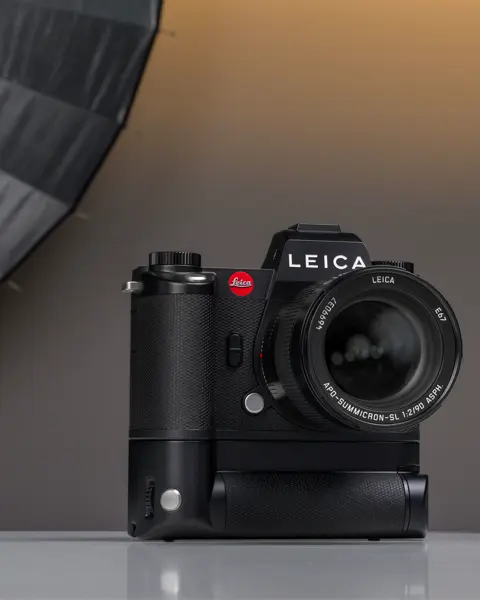A Leica camera placed on a table in a photography studio setting