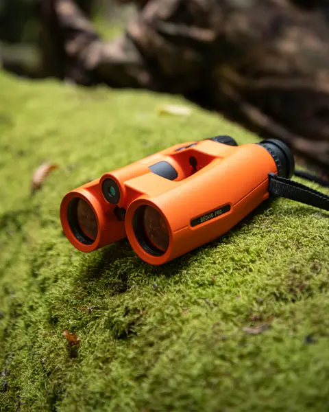 Leica-Geovid-Pro-Orange-lying-on-a-moss-covered-tree-trunk