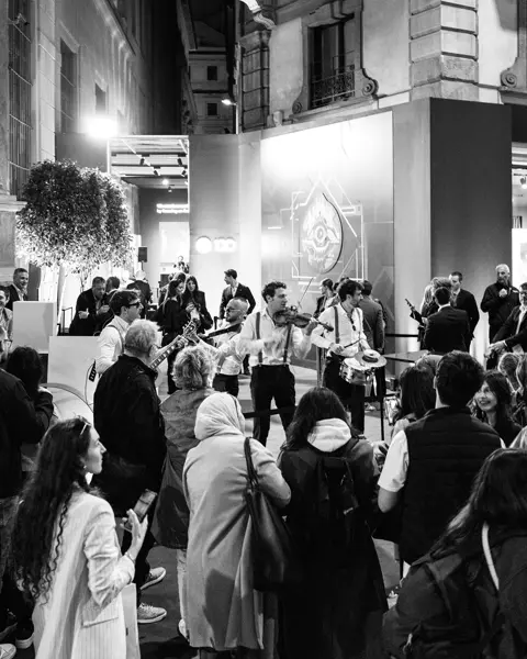 Guests at the celebrations stand in front of the Leica Store in Milan watching street musicians.