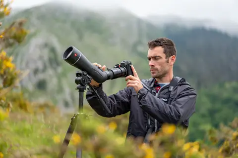 Man is digiscoping with his Leica APO-Televid spotting scope