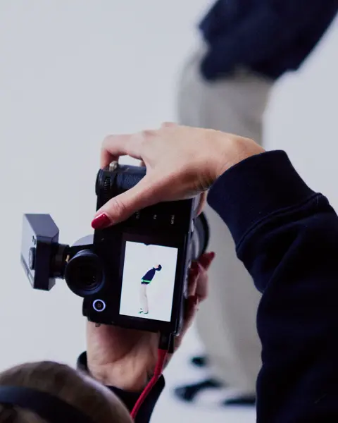 Photographer from behind in a photo studio photographing a man