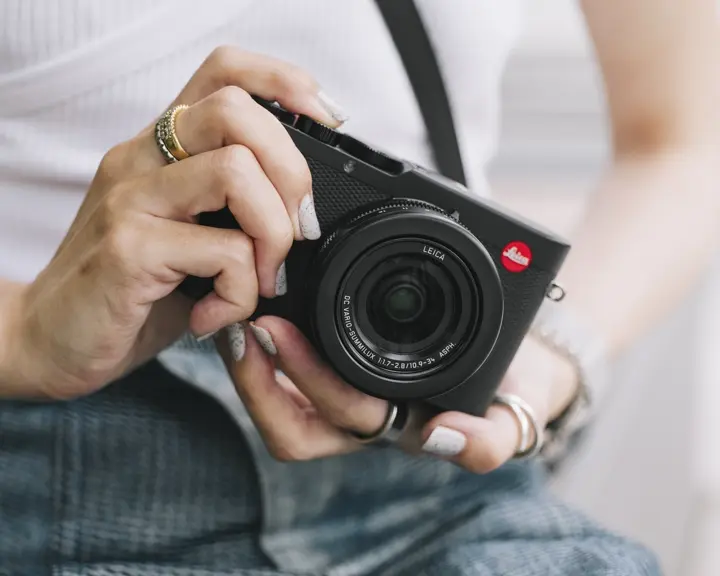 woman with a leica compact camera in his hands