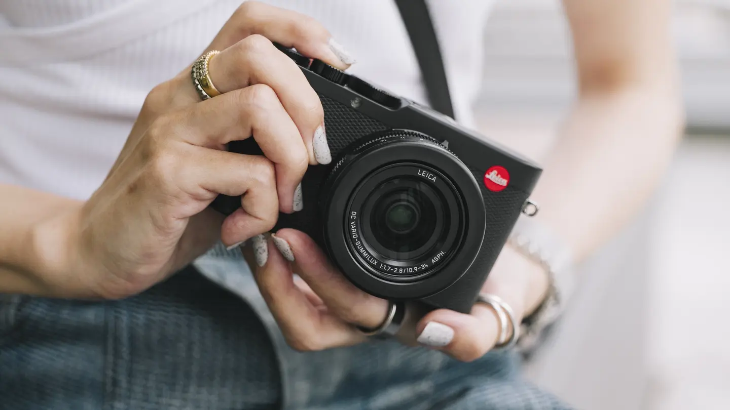 woman with a leica compact camera in his hands