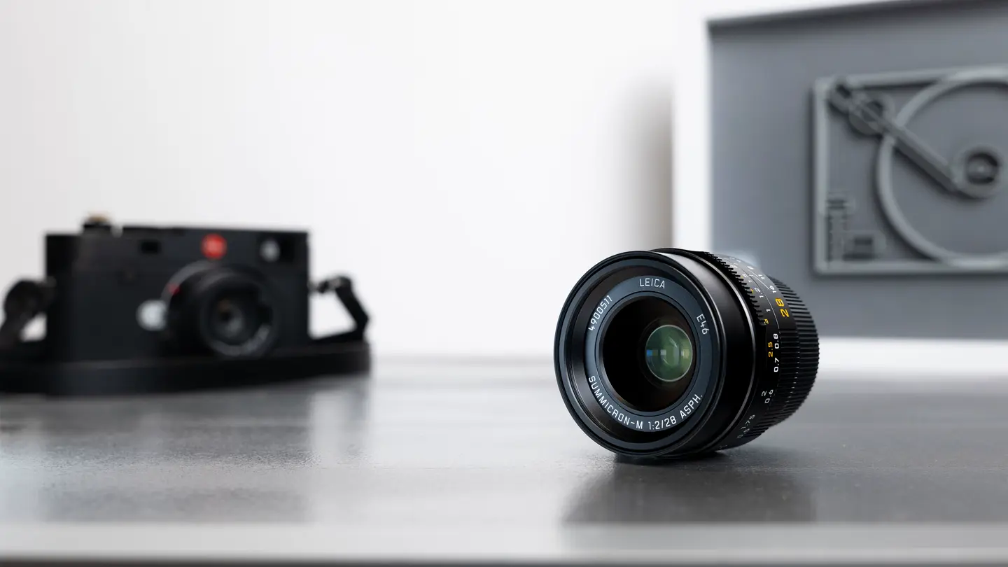 Leica camera with a Lens laying on a table.