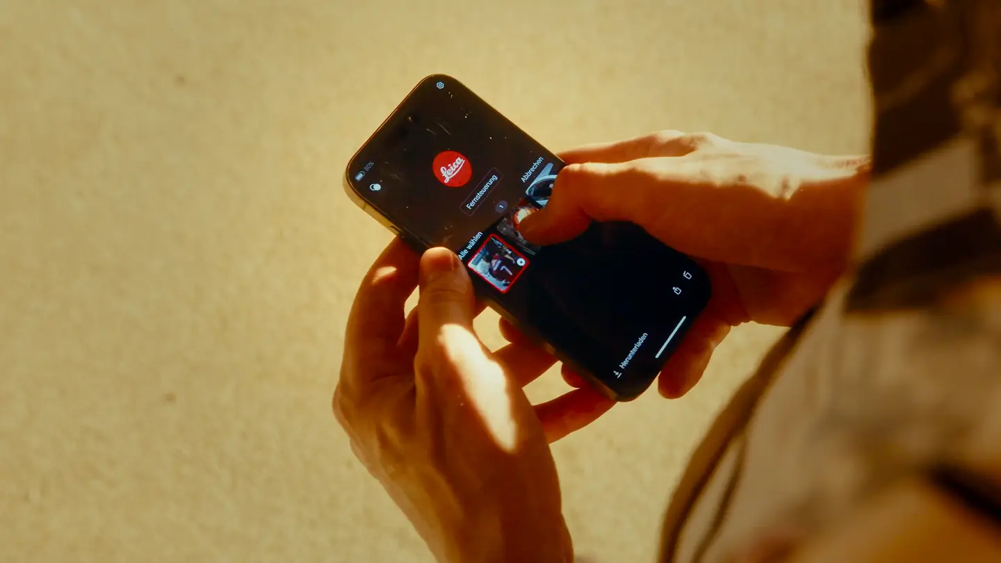 Man with a smartphone with the Leica app