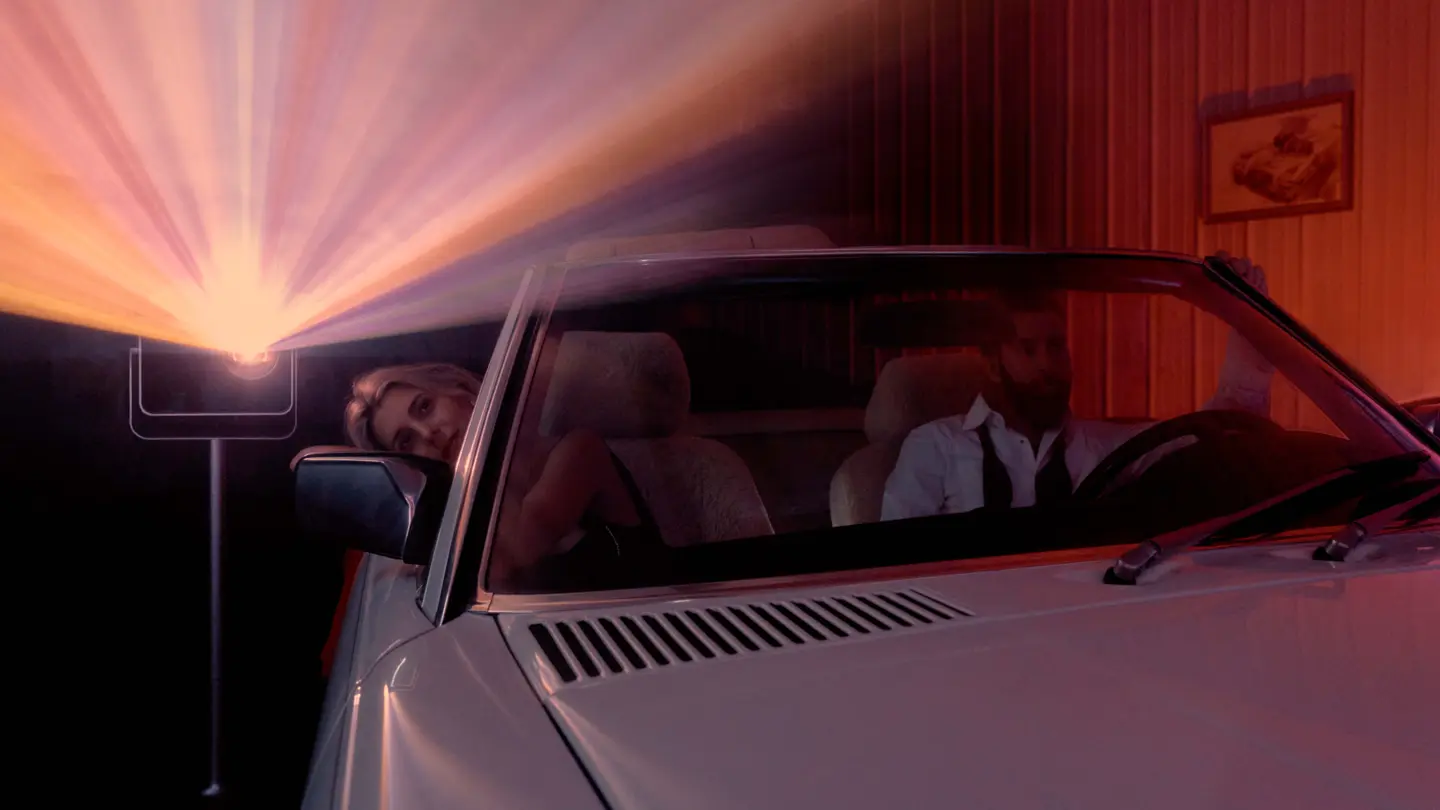 Two people sitting in a car watching a Leica Cine Play 1 projection.