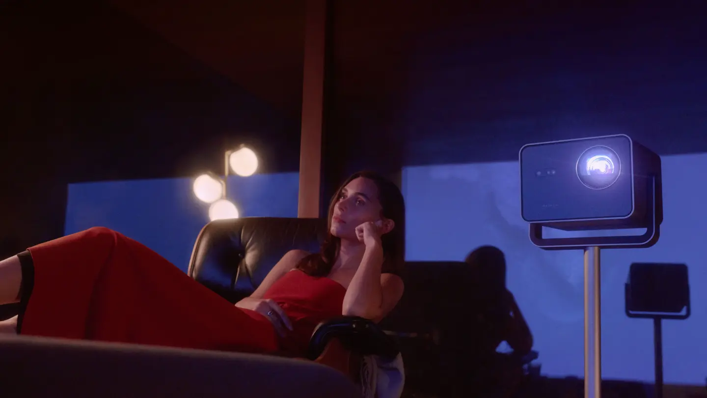 A woman watching a Leica Cine Play projection in the evening.