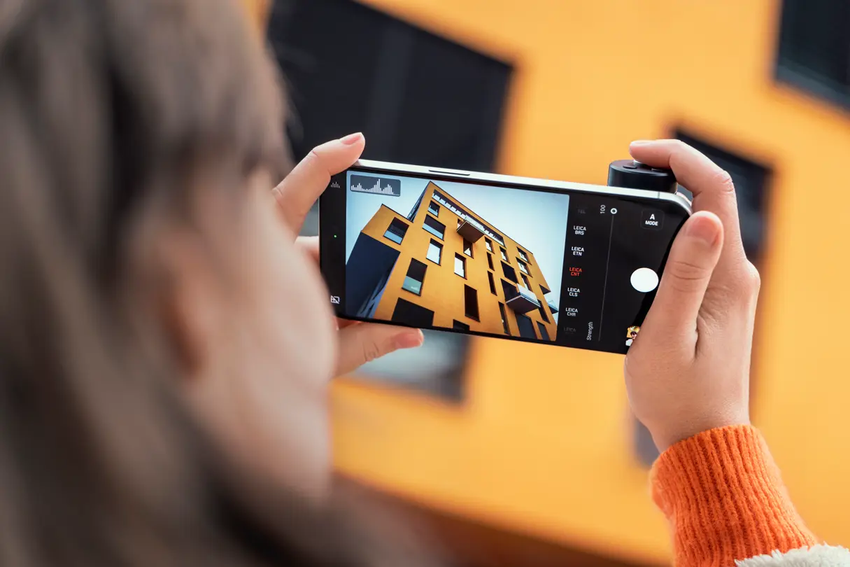 Display of the iPhone shows what the woman is photographing with the LUX grip