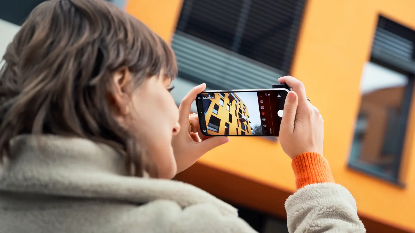 Woman photographing with the Leica LUX Grip