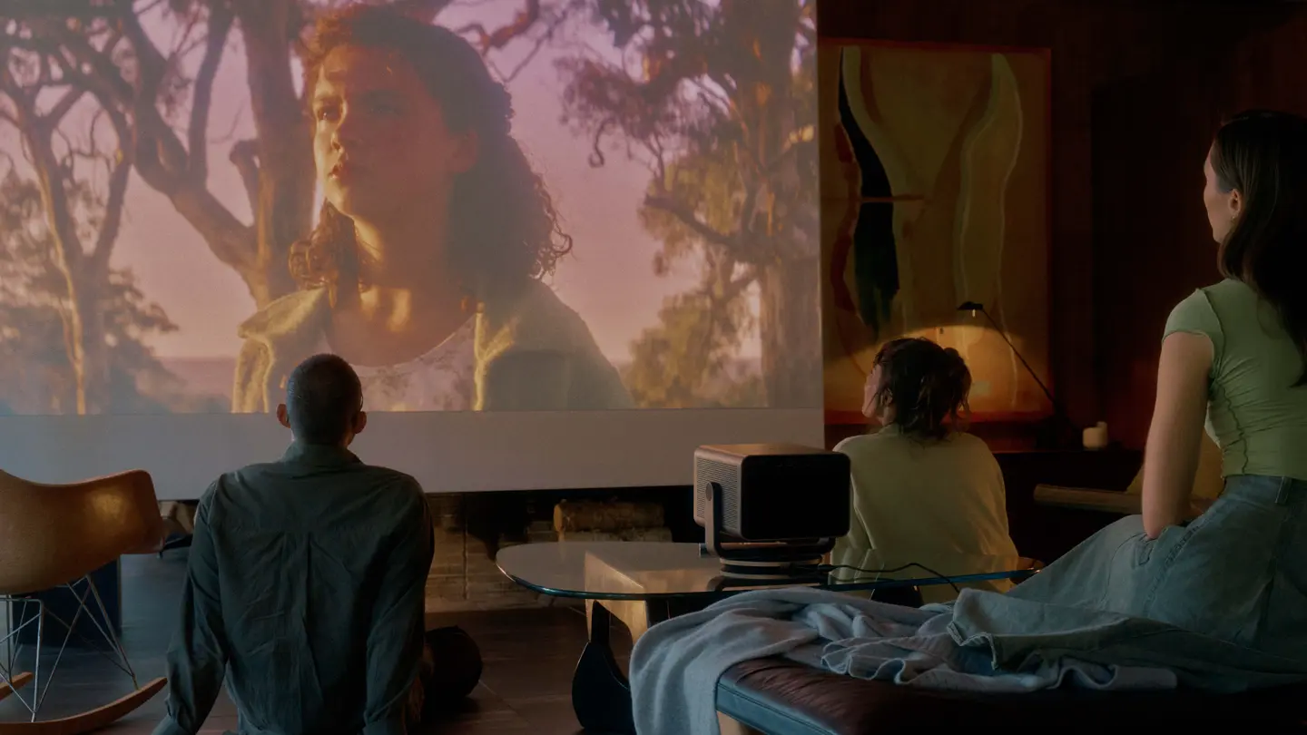 People sitting outside watching a Leica Cine Play 1 projection.