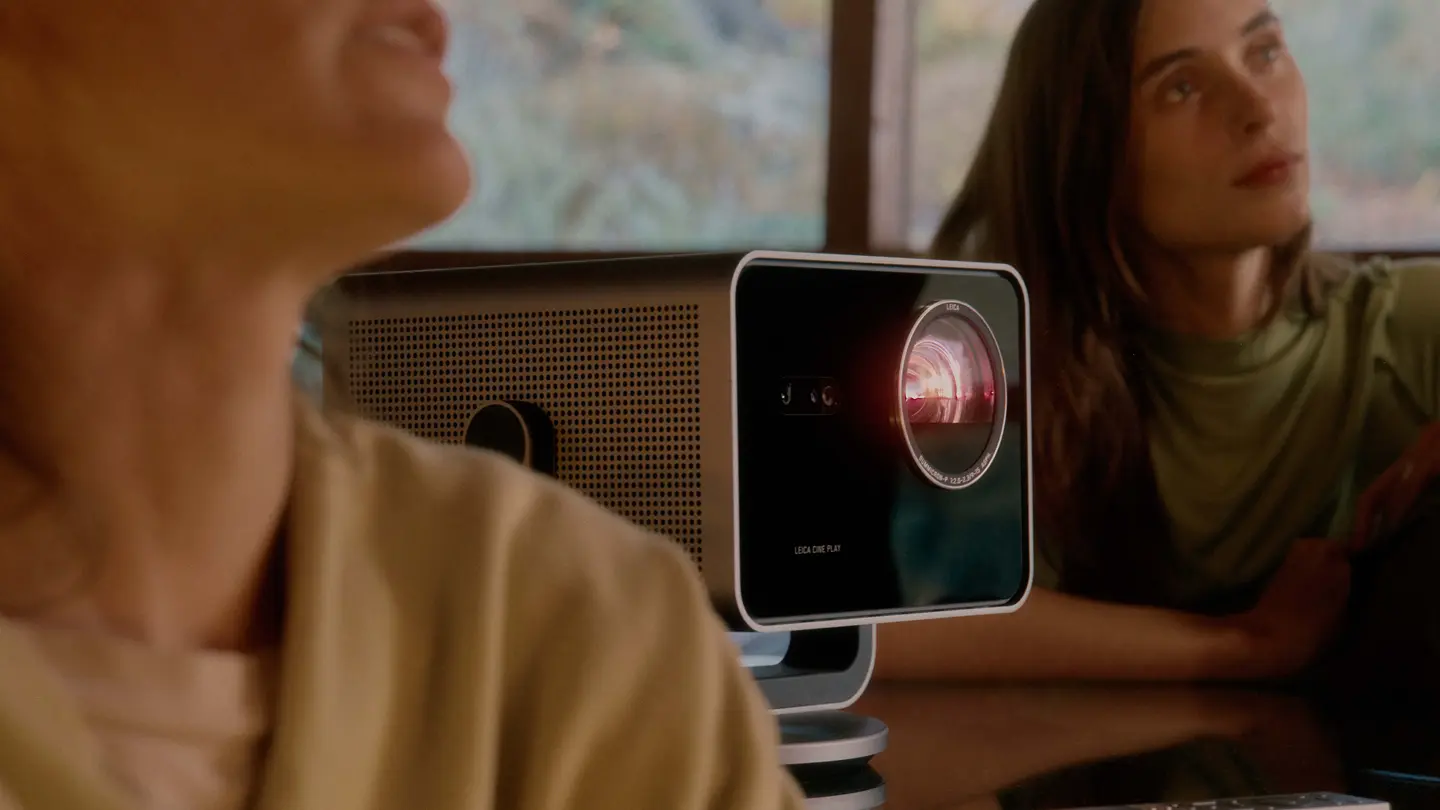 Two people sitting next to the Leica Cine Play 1.