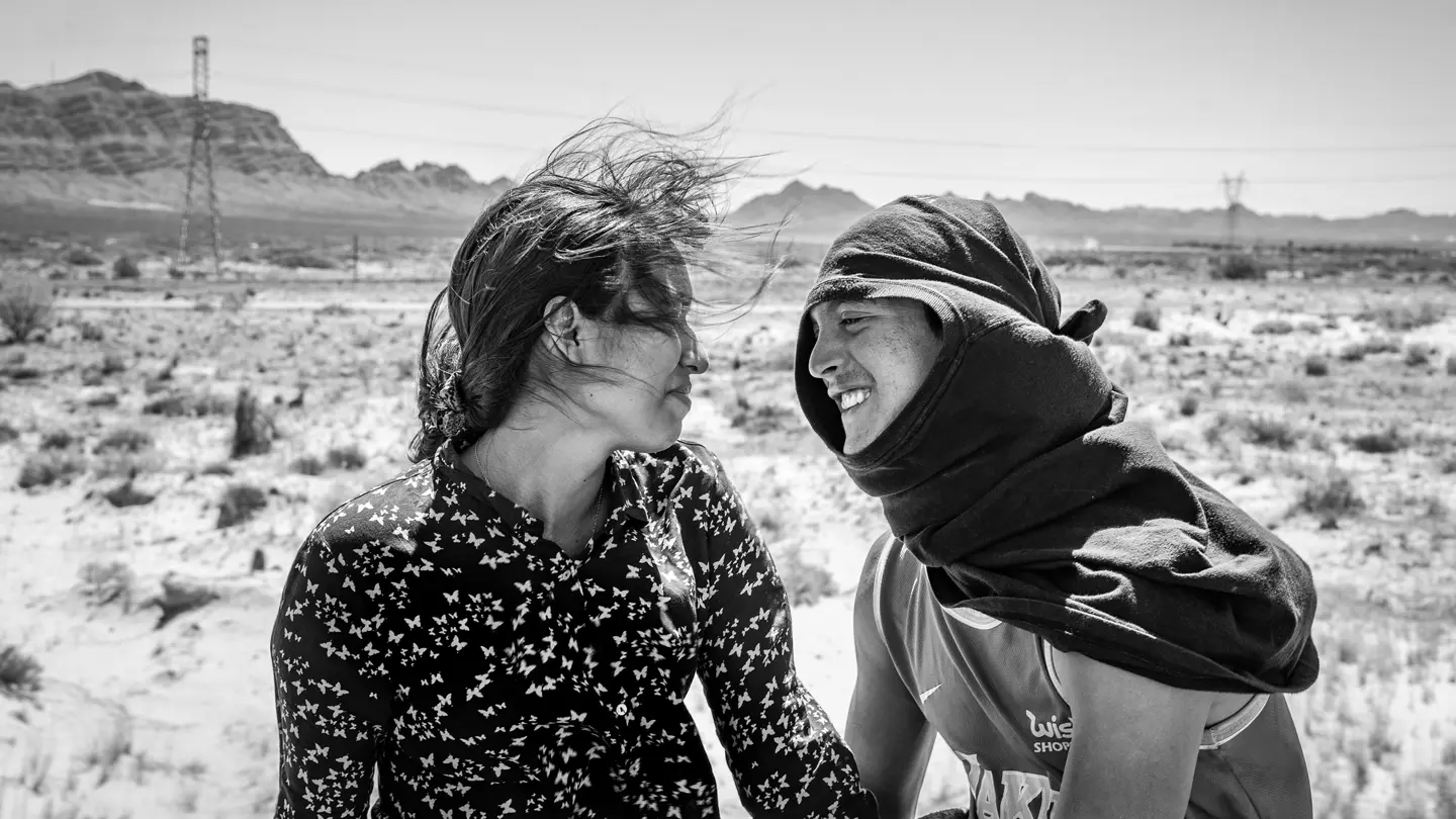 A young woman and young man look at each other.