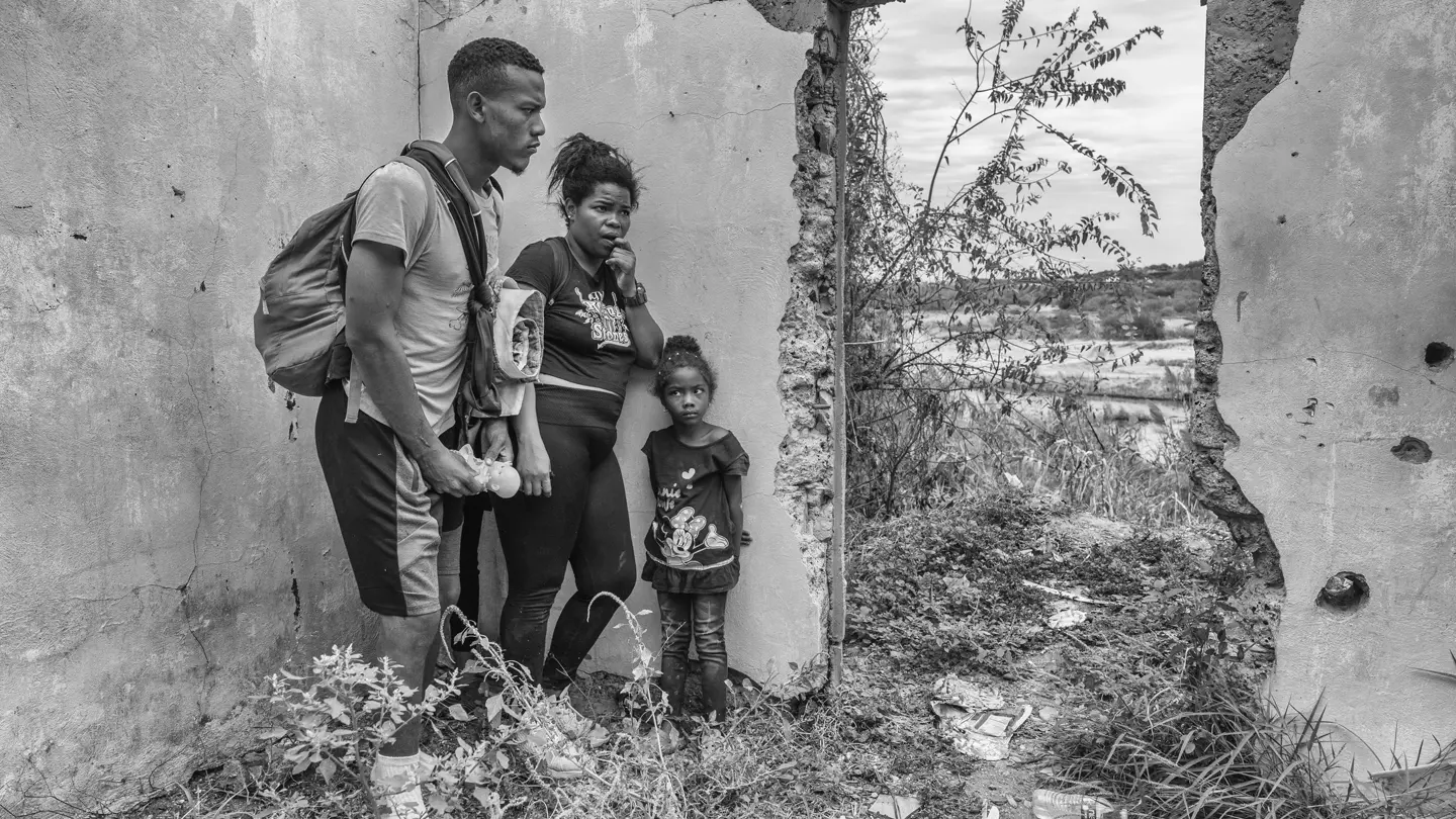Young parents standing with their daughter in a ruin.