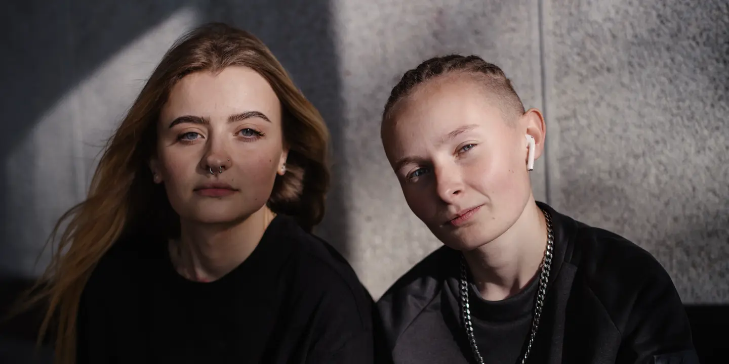 Two women sitting together and looking directly at the camera.