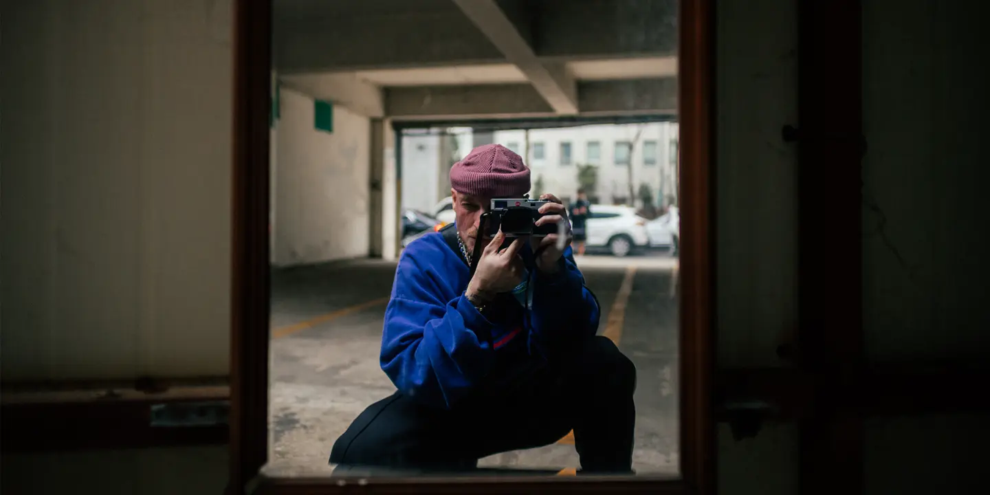 A man takes a picture of himself in a mirror in a garage.