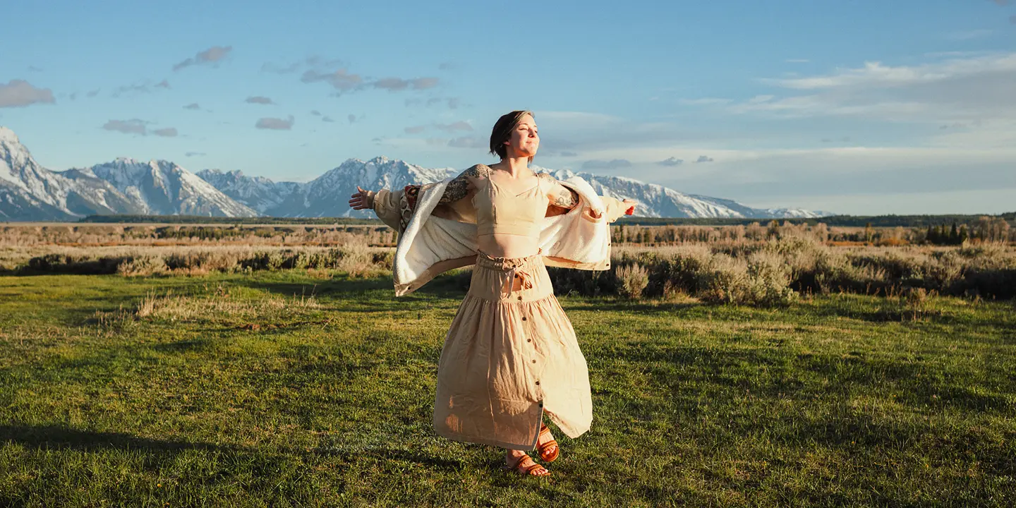 Happy woman with white dress on a meadow
