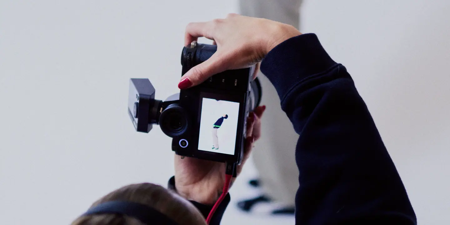 Photographer from behind in a photo studio photographing a man