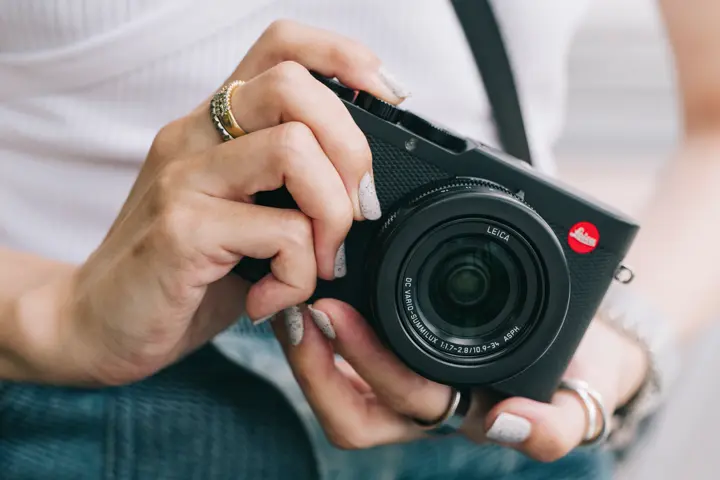 Woman holds camera d-lux 8 in her hands