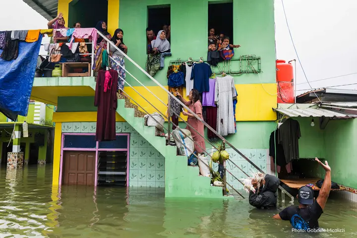 house standing in the water people waving