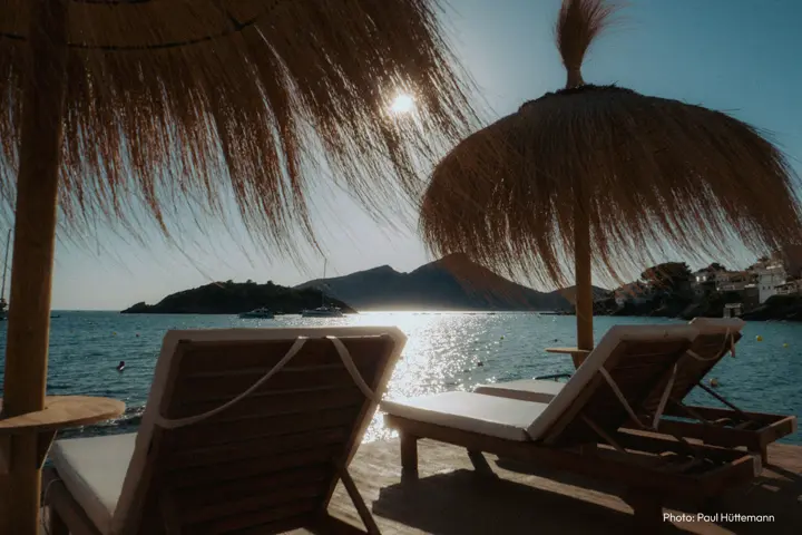Two sun loungers by the water