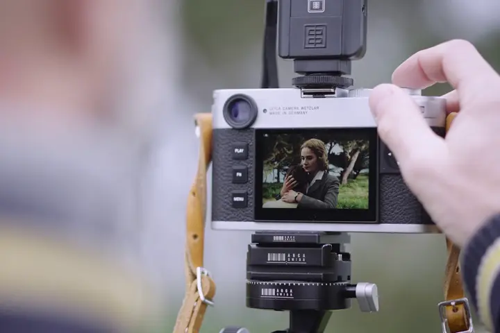 Hand presses shutter button and snaps a picture of a kiss