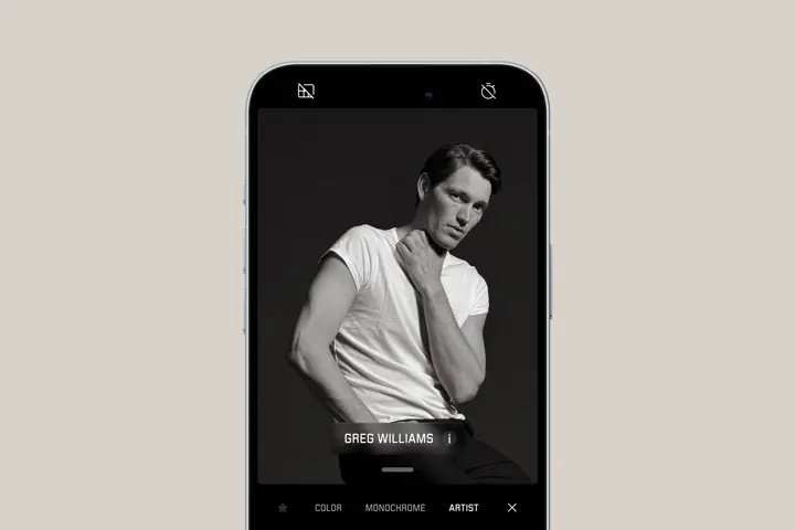 Smartphone shows portrait of a man posing for the camera in Greg Williams artist look