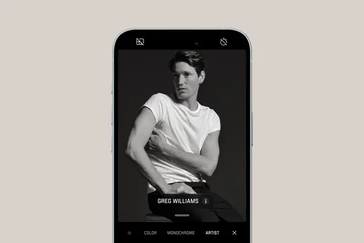 Smartphone shows portrait of a man posing for the camera in Greg Williams artist look