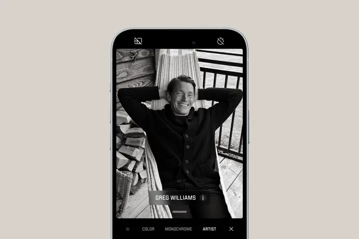 Smartphone shows portrait of a man laying in a hammock in Greg Williams artist look