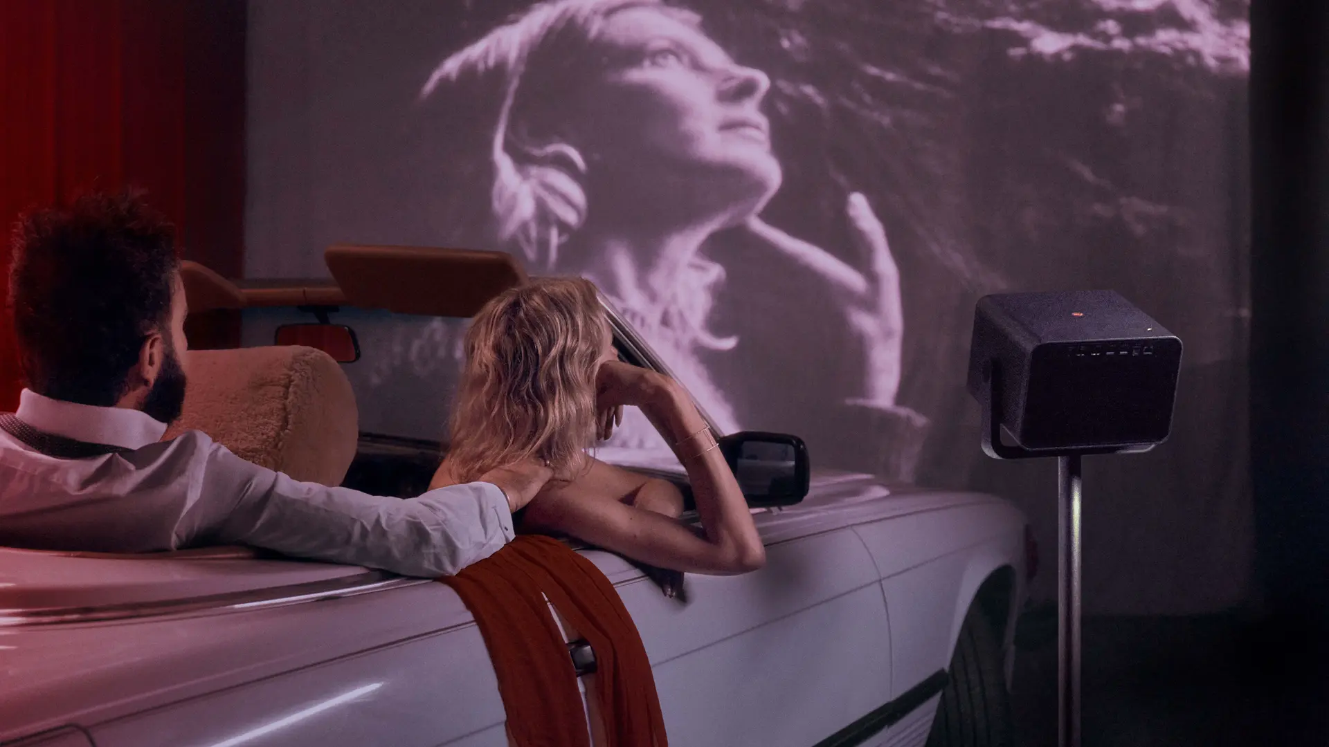 A couple is watching a movie from their car