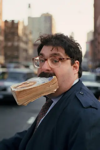 Man with a book in his mouth